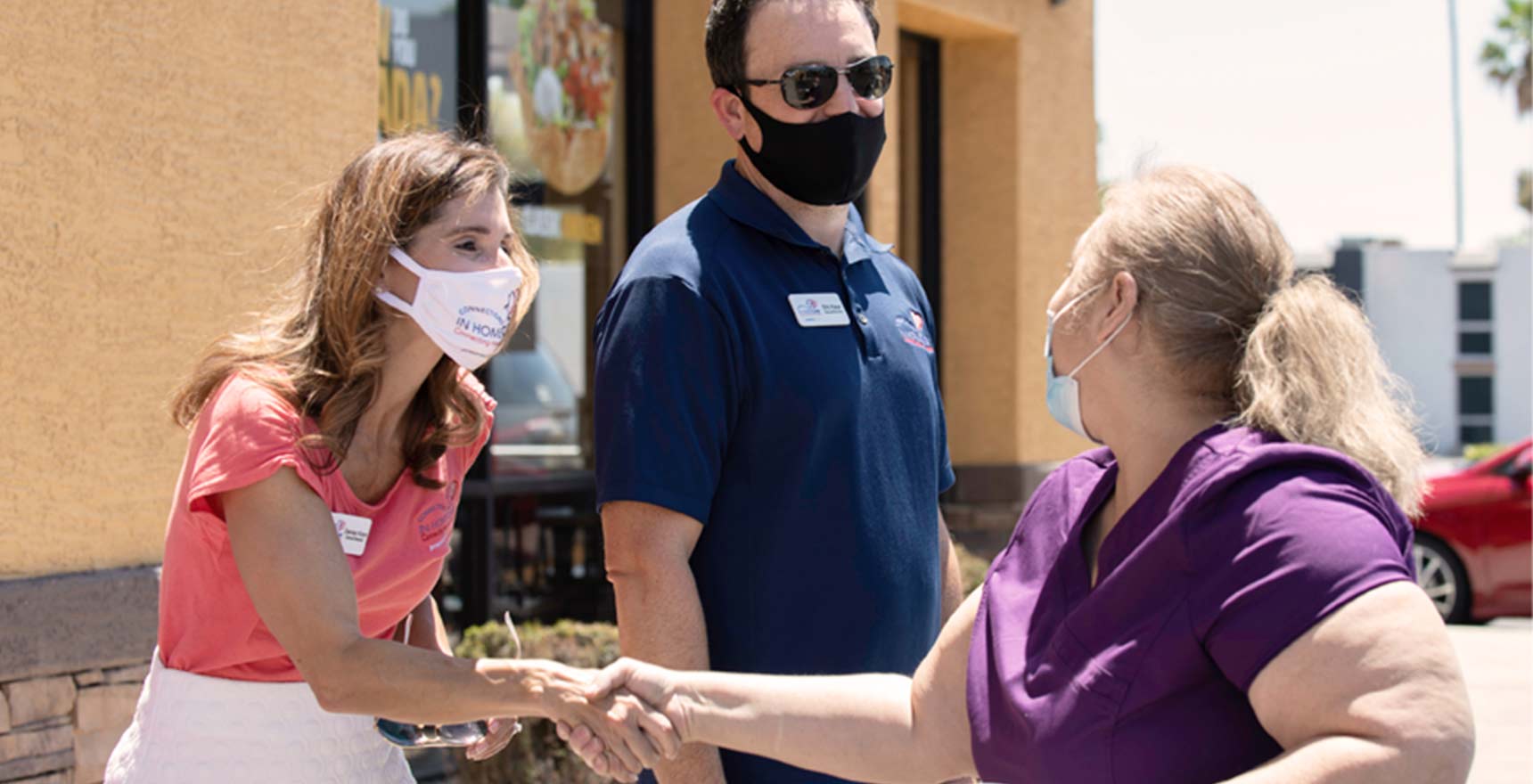 Care and health professionals shake hands outside