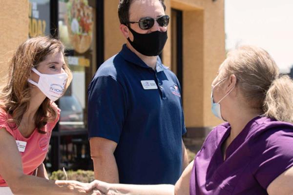 Care and health professionals shake hands outside