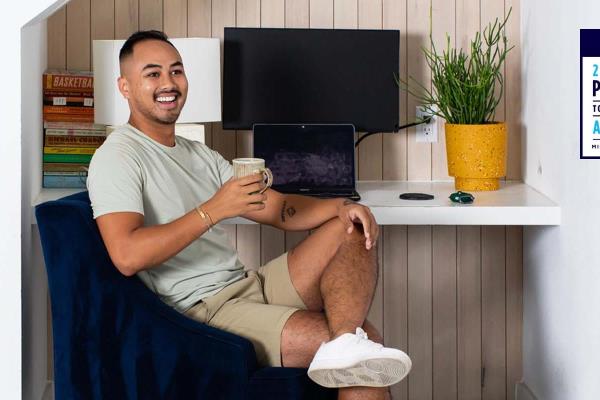 Professional man sits and smiles in home office