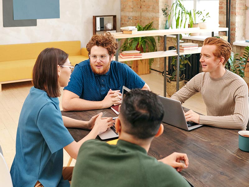 Group of honor professionals sit at table and discuss a solution