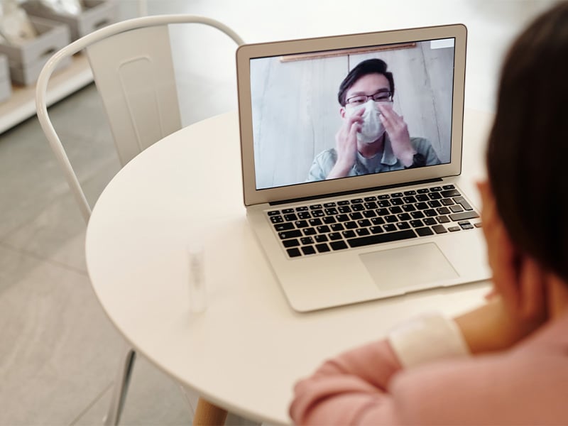 Woman in a video call with a COVID 19 patient wearing a mask