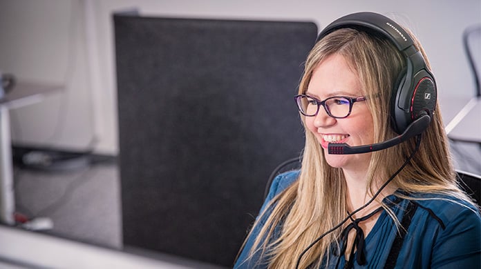 Professional woman sitting and working on headset